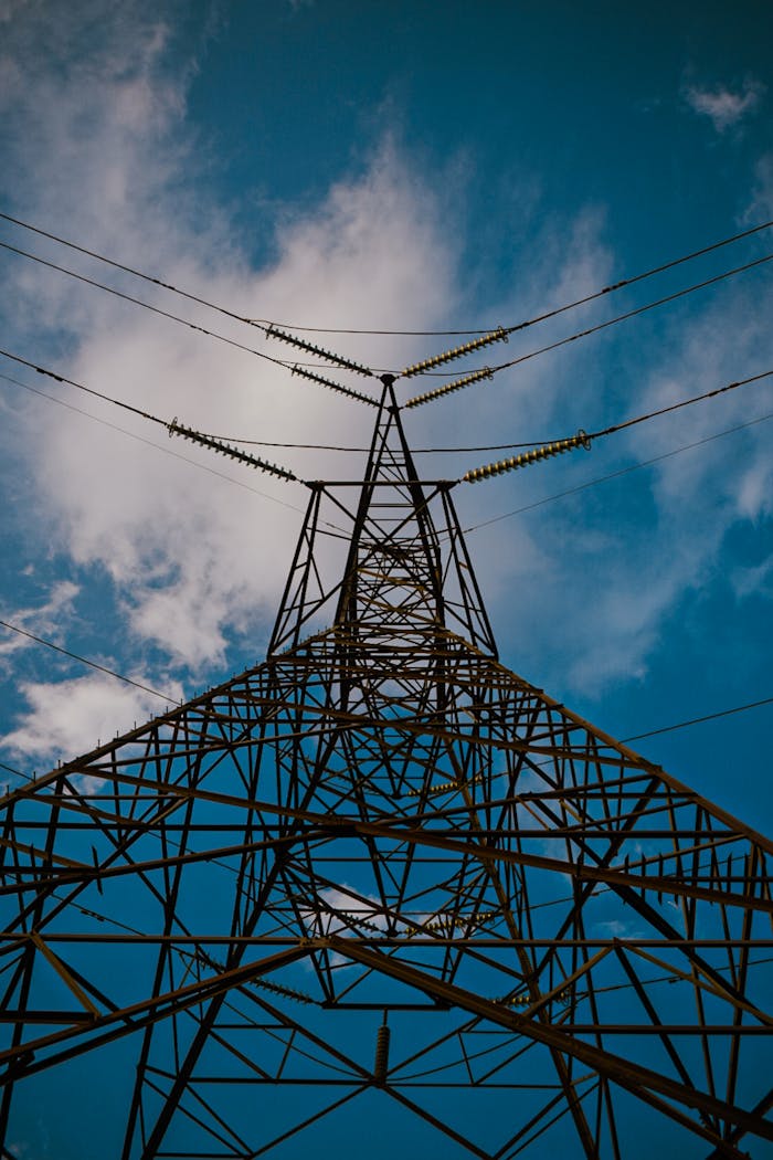 A dramatic view of a steel power pylon reaching into the sky, showcasing modern energy infrastructure.