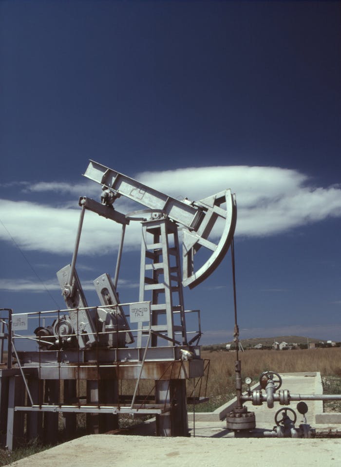 services-04 Oil pumpjack in operation against clear blue sky, highlighting industrial energy production.